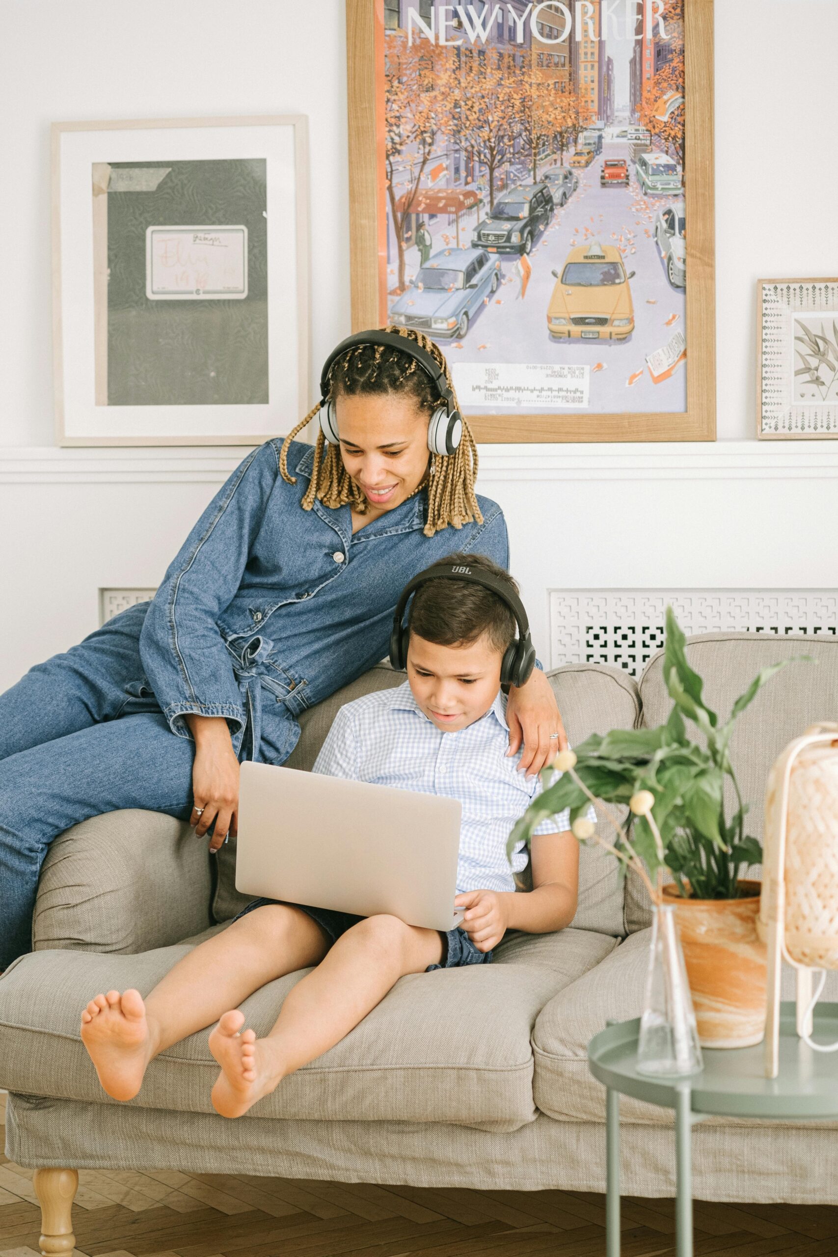 Woman smiling with her son listing to music on their laptop