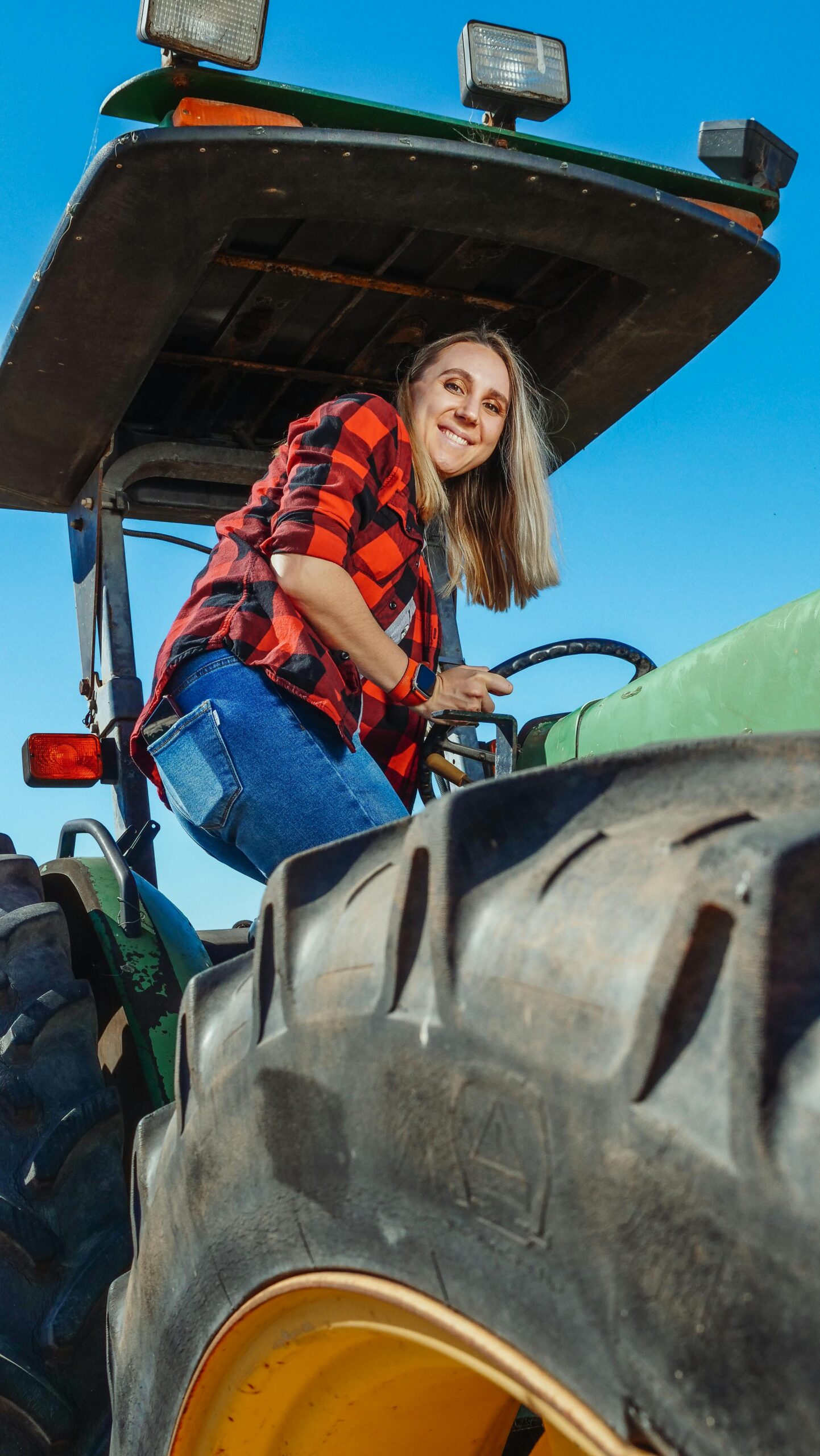 A woman getting on her financed tractor